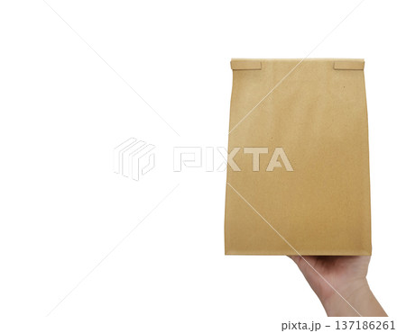 The man is holding an empty brown paper bag in his hand, with space left for an advertising message. The man is holding an empty brown paper bag in his hand, with space left for an advertising message. 137186261