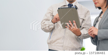 オフィスでタブレットを使って説明する作業員 オフィスでタブレットを使って説明する作業員 137186481