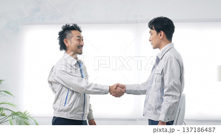オフィスで握手する作業員のグループ 137186487