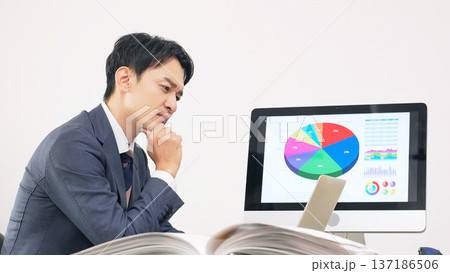 オフィスで仕事をしながら悩む男性ビジネスパーソン オフィスで仕事をしながら悩む男性ビジネスパーソン 137186506