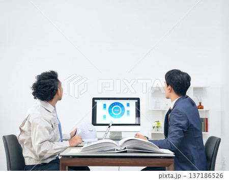 オフィスで会議するビジネスパーソンと作業員のグループ オフィスで会議するビジネスパーソンと作業員のグループ 137186526