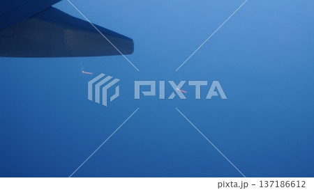 Airplane wing above clouds with distant lights visible in the sky 137186612