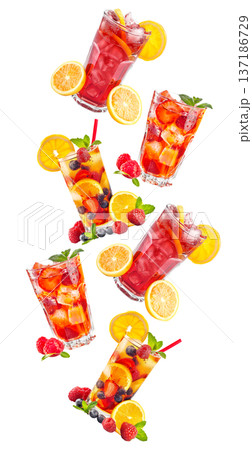 Savor a refreshing iced raspberry beverage with fruit and mint under the warm summer sun 137186729