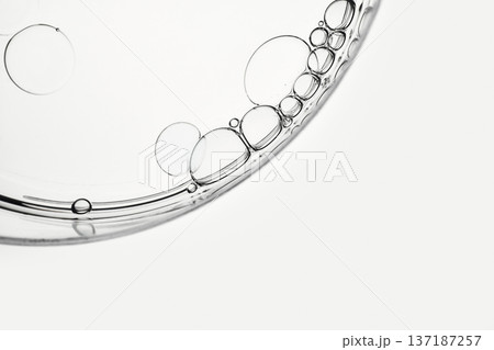 Oil droplets creating abstract patterns in transparent petri dish 137187257