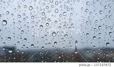 Fresh raindrops on window glass against blurred city background, rainy weather concept, water drops pattern macro, condensation surface texture clean liquid moisture Fresh raindrops on window glass against blurred city background, rainy weather concept, water drops pattern macro, condensation surface texture clean liquid moisture 137187672