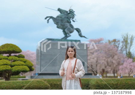 Woman tourist sightseeing Kajo Park Yamagata Castle Ruins with Sakura Cherry Blossom in Spring, happy traveler travel in Yamagata prefecture, Tohoku, Japan. famous Landmark for Travel and Vacation 137187998