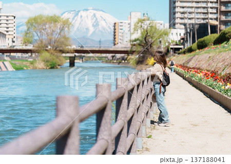 Woman tourist sightseeing Iwate mountain and Kitakami river with flowers in Spring, happy traveler travel in Morioka city, Iwate prefecture, Japan. famous Landmark Travel and Vacation destination Woman tourist sightseeing Iwate mountain and Kitakami river with flowers in Spring, happy traveler travel in Morioka city, Iwate prefecture, Japan. famous Landmark Travel and Vacation destination 137188041