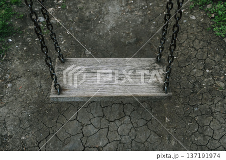 Lonely Wooden Swing Over Cracked Earth in Dark Melancholic Atmosphere Lonely Wooden Swing Over Cracked Earth in Dark Melancholic Atmosphere 137191974
