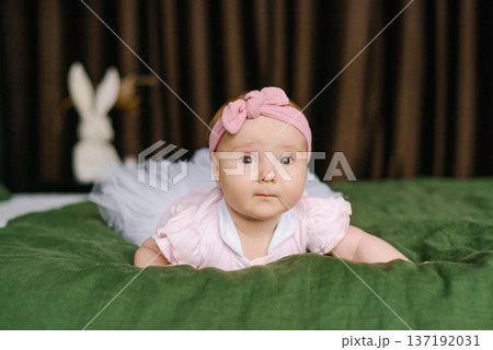 Baby Girl In Pink Headband Crawling On Green Blanket Baby Girl In Pink Headband Crawling On Green Blanket 137192031