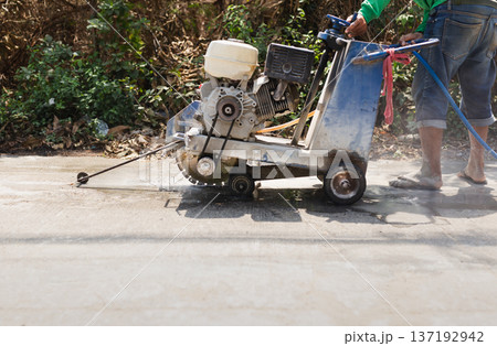 Close up of a concrete floor saw cutting through pavement with water cooling system. 137192942