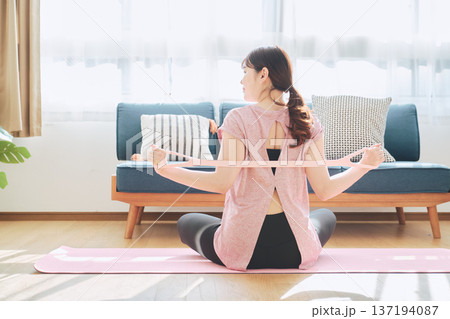 トレーニングチューブで背中のストレッチをする女性のホームフィットネス 137194087