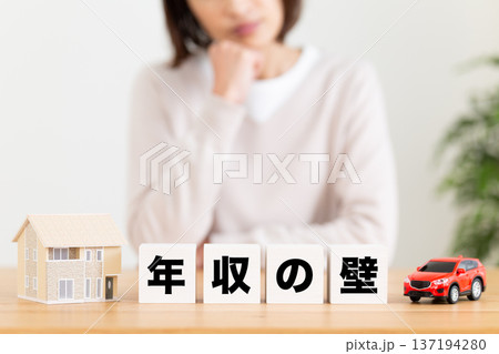 年収の壁のブロックと悩むミドル女性 年収の壁のブロックと悩むミドル女性 137194280