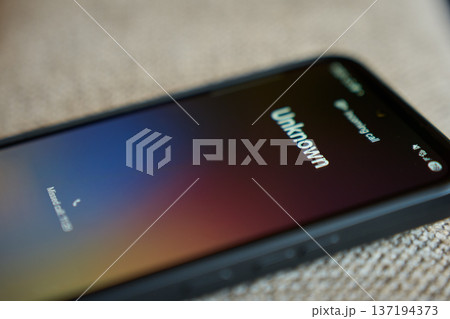 Close up of smartphone with unknown incoming call on screen. Concept of mobile communication, spam call risk and privacy concern. 137194373