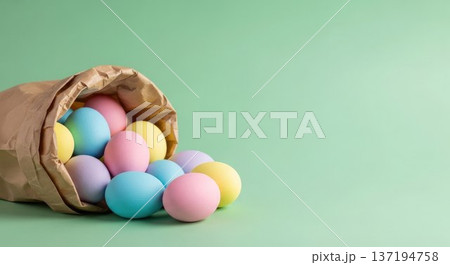 Colorful Easter eggs spilling from a brown paper bag on a light green background. The eggs are pastel shades of pink, blue, yellow, and green, symbolizing spring. Colorful Easter eggs spilling from a brown paper bag on a light green background. The eggs are pastel shades of pink, blue, yellow, and green, symbolizing spring. 137194758