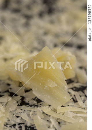 hard ripe cheese grated into small pieces for cooking pasta or pizza, grated of yellow quality cheese as an ingredient for a large dish 137196570