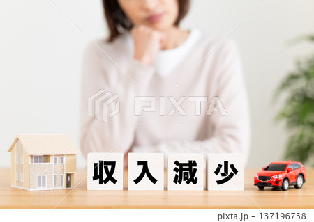 収入減少のブロックと悩むミドル女性 収入減少のブロックと悩むミドル女性 137196738