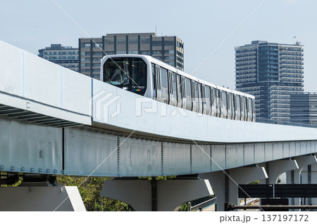 View of a New Transit Yurikamome line train running on the elevated track in Koto, Tokyo, Japan. It's an automated guideway transit service in Tokyo. 137197172