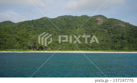 View form boat of Seychelles La Digue Island with sandy beach and lush forest in January 137197770
