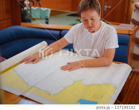 Woman Sailor Studying Navigation Map Inside Yacht Cabin Interior 137198182
