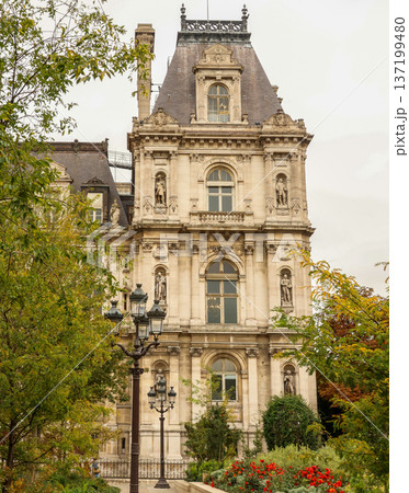 Hotel de Ville in Paris, France, showing Renaissance architecture, ornate details, and garden with red flowers 137199480