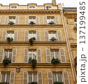 Paris urban architecture with classical Haussmann building facade, windows, and blooming flowerboxes 137199485