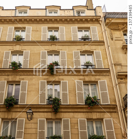 Paris urban architecture with classical Haussmann building facade, windows, and blooming flowerboxes 137199485