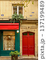 Paris urban architecture featuring vibrant red door, green storefront with awning, and detailed building facade 137199489