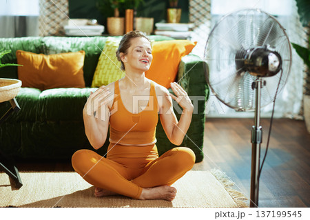 Smiling Woman Enjoying Summer Fan Breeze 137199545