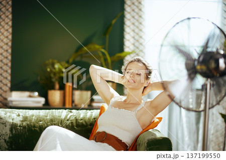 Relaxed Woman Enjoying Fan Breeze in Summer 137199550