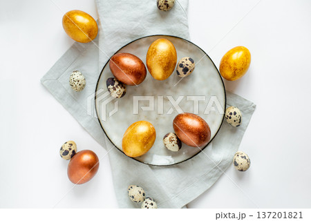 Golden and bronze Easter eggs in a grey plate 137201821