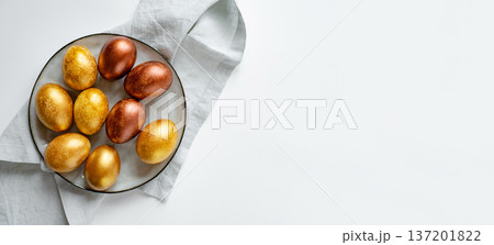 Golden and bronze Easter eggs in a gray plate Golden and bronze Easter eggs in a gray plate 137201822
