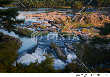夕日に照らされる紅葉と滝 137201954