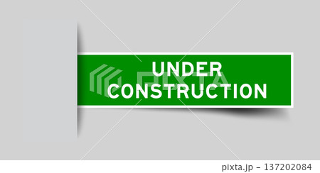 Green color square label sticker with word under construction that inserted in gray background 137202084
