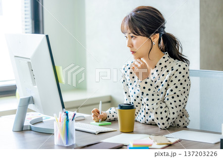 オフィスでパソコンを操作する若い女性 オフィスでパソコンを操作する若い女性 137203226