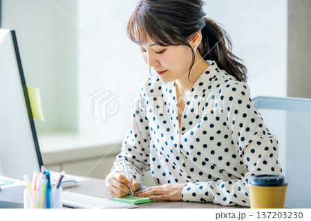 オフィスでパソコンを操作する若い女性 オフィスでパソコンを操作する若い女性 137203230