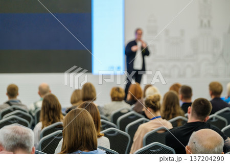 Audience listening to speaker during business conference presentation in modern meeting room Audience listening to speaker during business conference presentation in modern meeting room 137204290