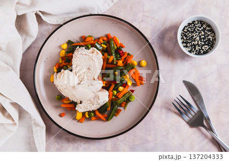 Boiled chicken fillet and mixed vegetables on a plate on the table top view Boiled chicken fillet and mixed vegetables on a plate on the table top view 137204333