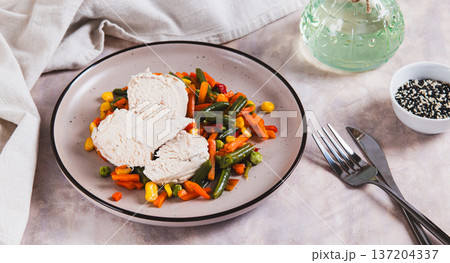 Boiled chicken fillet and mixed vegetables on a plate on the table web banner 137204337