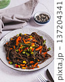 Buckwheat soba noodles with vegetables on a plate on the table vertical view 137204341