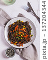Buckwheat soba noodles with vegetables on a plate on the table top and vertical view 137204344