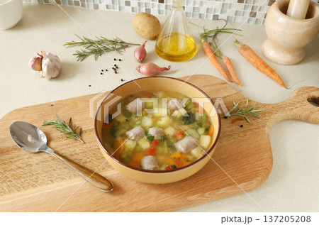Traditional Italian minestrone soup with vegetables, sausage, served in clay bowl on wooden board. Food and healthy lifestyle. Mediterranean cuisine. Traditional Italian minestrone soup with vegetables, sausage, served in clay bowl on wooden board. Food and healthy lifestyle. Mediterranean cuisine. 137205208