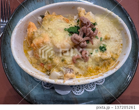 Rich baked seafood dish featuring cheese crust and parsley garnish Rich baked seafood dish featuring cheese crust and parsley garnish 137205261