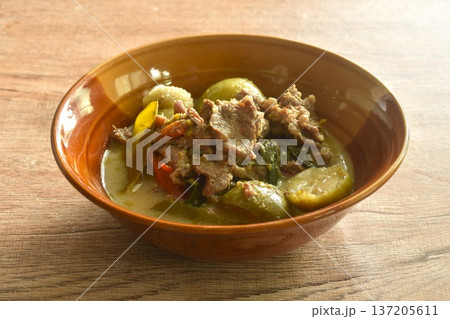 spicy boiled slice beef meat with lemon leaf and eggplant in coconut milk green curry soup on bowl 137205611