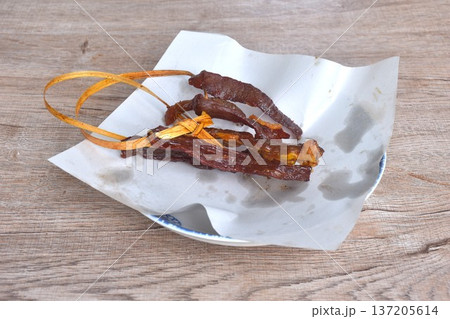 fried crispy salty fermenting beef fat meat with pepper string in straw robe on plate fried crispy salty fermenting beef fat meat with pepper string in straw robe on plate 137205614