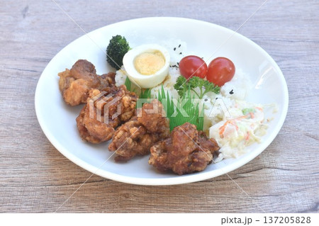 crispy fried chicken garic in shoyu sauce with boiled egg on black sesame rice topping tomato couple coleslaw salad Japanese bento set on plate crispy fried chicken garic in shoyu sauce with boiled egg on black sesame rice topping tomato couple coleslaw salad Japanese bento set on plate 137205828