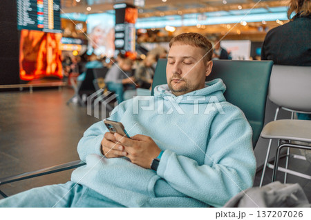 Male traveler waiting at airport terminal with luggage 137207026