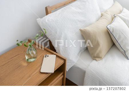 ベッドサイドのチェストの上に置かれたスマートフォン ベッドサイドのチェストの上に置かれたスマートフォン 137207802