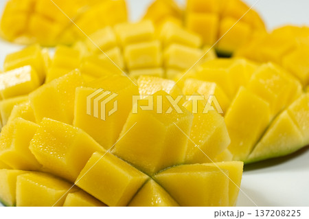 Juicy mango halves with cube cut pattern. Juicy mango halves with cube cut pattern. 137208225