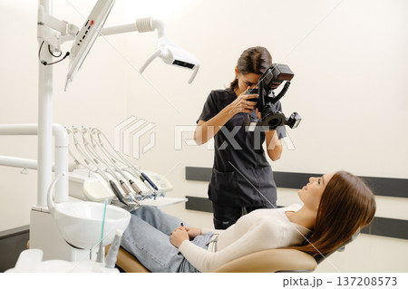 Dentist woman photographing with professional camera the result of her work in clinic 137208573