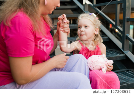 Child girl with cochlear implant with her mother spend time outdoor. Hear impairment and deaf community concept. Deaf and health concept. Disability and inclusion. Copy space Child girl with cochlear implant with her mother spend time outdoor. Hear impairment and deaf community concept. Deaf and health concept. Disability and inclusion. Copy space 137208652